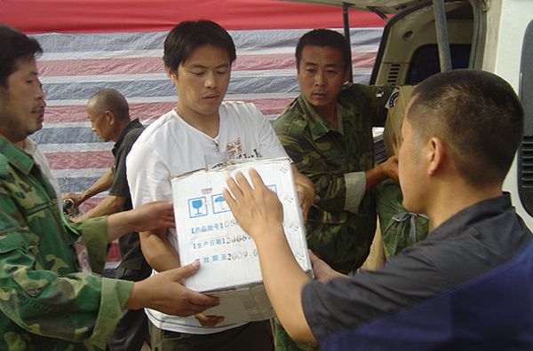 朱及(左一)在绵竹灾区现场发放救灾物资_副本.jpg