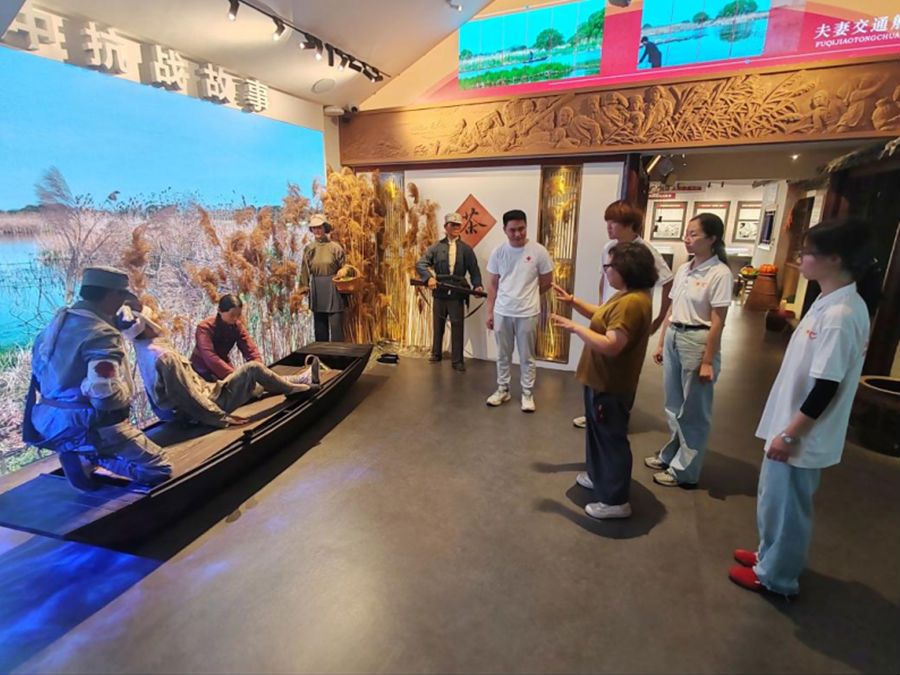 图为陆绪华女士为志愿队讲解芦苇荡中的运送伤员的故事 摄影 张鸿宇_副本.png